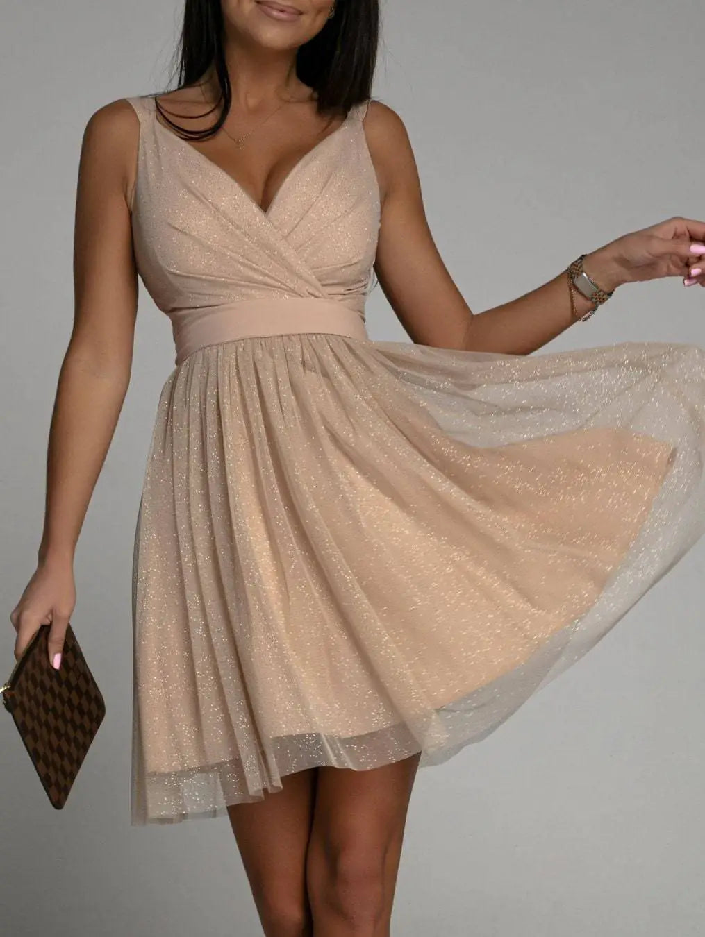 Elegant Glitter Sleeveless Deep V Neck Party Dress for Women in a light beige color with a flared skirt.